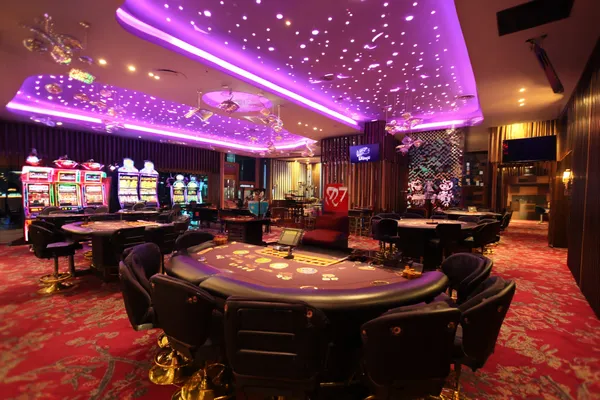 A man focused on his laptop with live stats in the background, highlighting the dedicated sports and gaming features of the QWE123 mobile app.