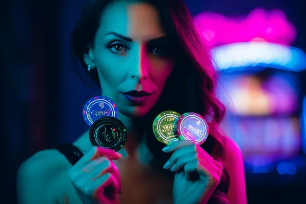 A woman smiling by bright slot machines showing lucky symbols, showcasing the exciting slot offerings at QWE123.